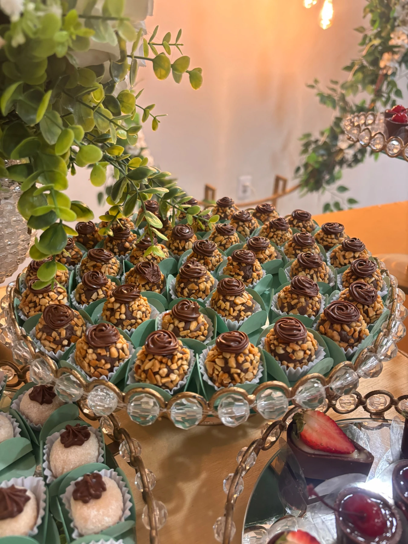 Doces da Fia com cobertura de castanhas em mesa de festa